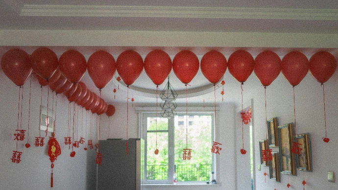 A room decorated with many red balloons and festive ornaments.